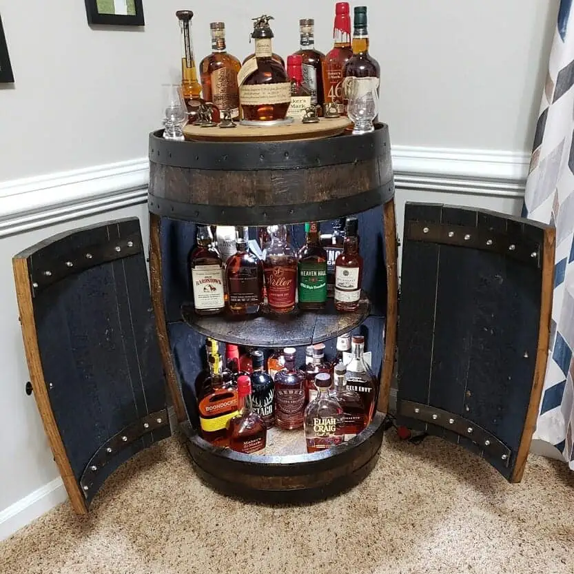 Whiskey barrel cabinet filled with bottles. Dark walnut finish color