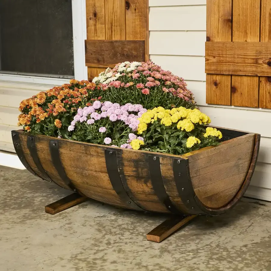 side view of whiskey barrel planters filled with colorful flowers