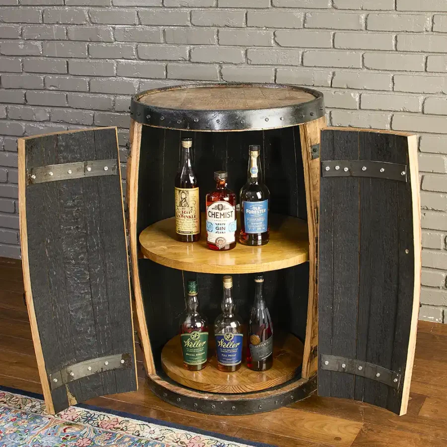 Whiskey barrel cabinet with tall doors. Lights turned off. 2 rotating shelves inside the barrel with bottles on each shelf.