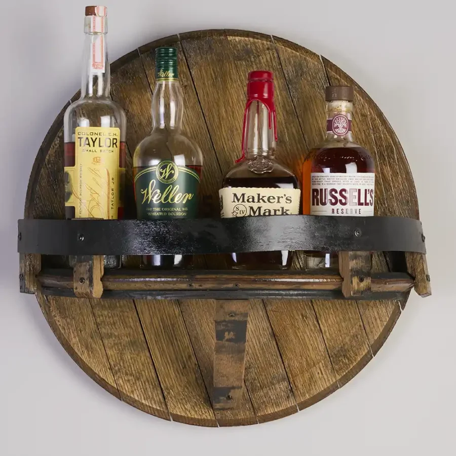 Whiskey barrel lid shelf with bottles on it. Metal ring painted black wrapped around the edge