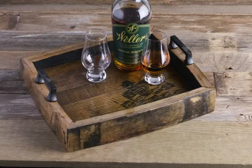 Whiskey barrel serving tray with bourbon bottle and glasses on it.