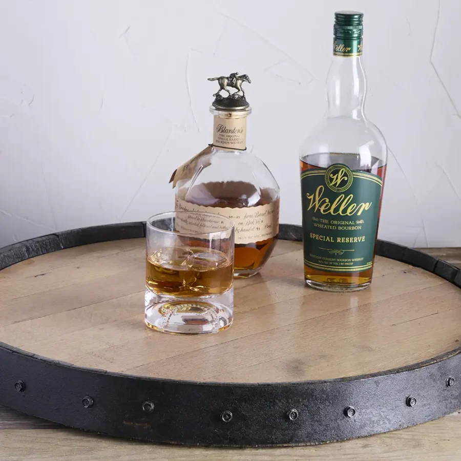 Barrel lazy susan with bottles of bourbon on it and whiskey glass