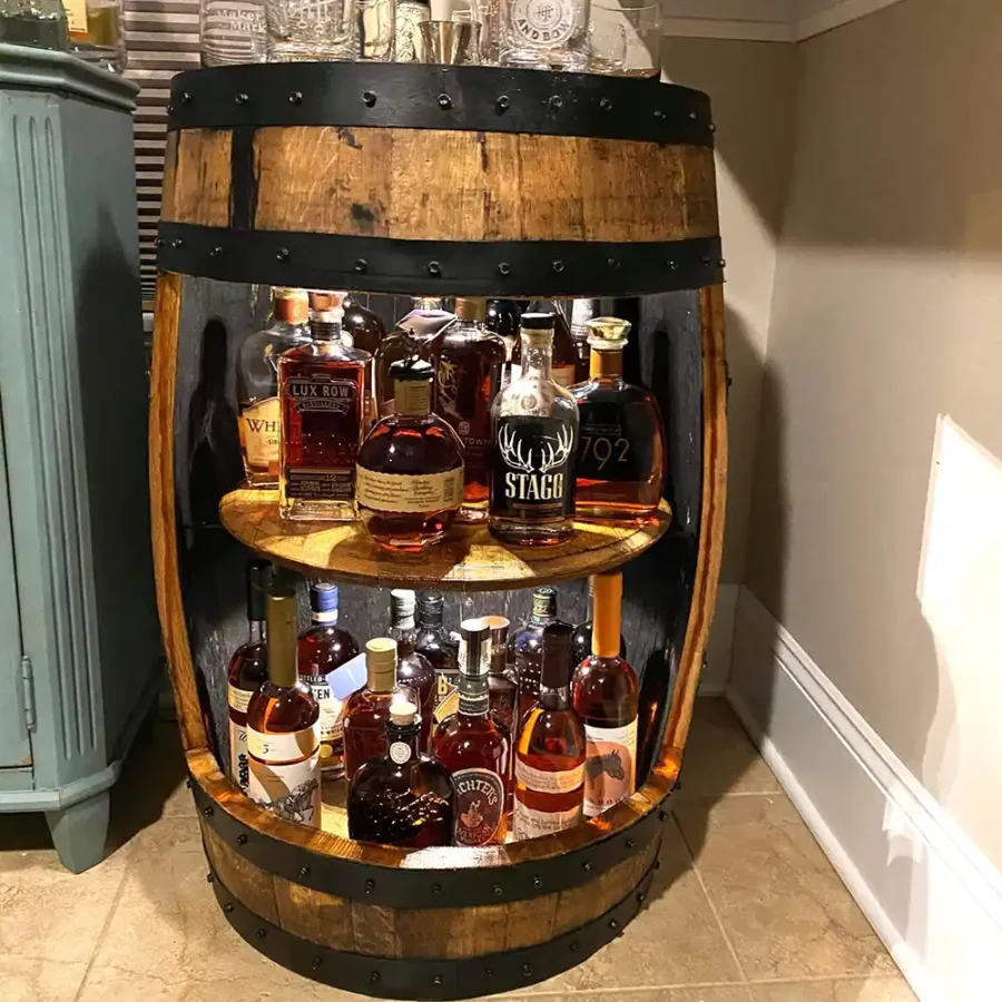 Whiskey barrel cabinet with liquor inside. Light colored wood with black metal rings